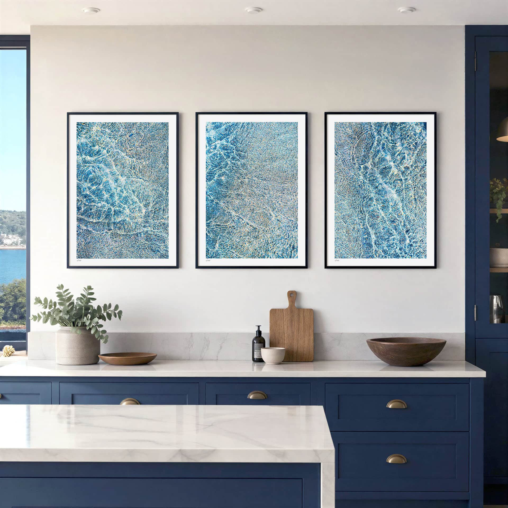 three images from the KOKO Studio Porthcothan Sapphire collection of fine art coastal inspired prints framed on a wall in a modern interior kitchen