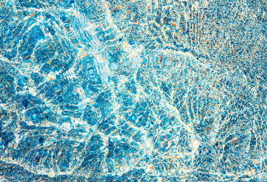 Fine Art Photographic print of reflections on water and sand creating abstract patterns of blue and white colours. Close up of a collectable coastal fine art print.