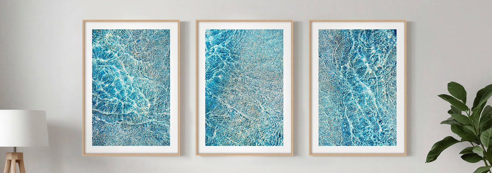 Three fine art photographic prints of crystal clear tropical waters in Cornwall framed on a white wall.